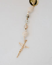Beaded Rosary with a gold cross pendant on a light gray background
