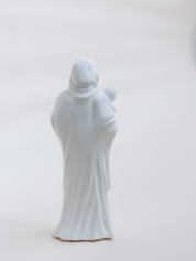 White statue of a mother holding a child on a light gray background
