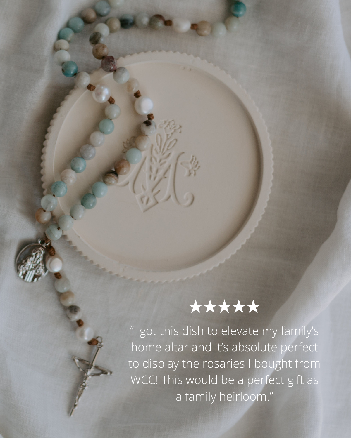Rosary dish with engraved Marian design and rosary on a textured surface