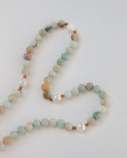 Beaded rosary with multicolored beads on a light gray background