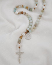 Rosary with multicolored beads and a cross on a white background
