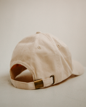 Beige cap with a gold buckle on a light background