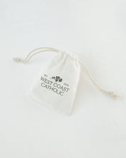 White drawstring bag with 'West Coast Catholic' text on a white background
