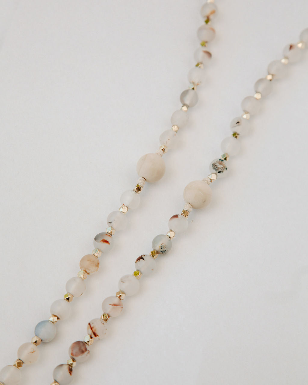 Rosary with multicolor beads and gold accents on a light background