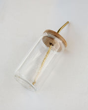 Clear glass drink container with wooden lid on a white background