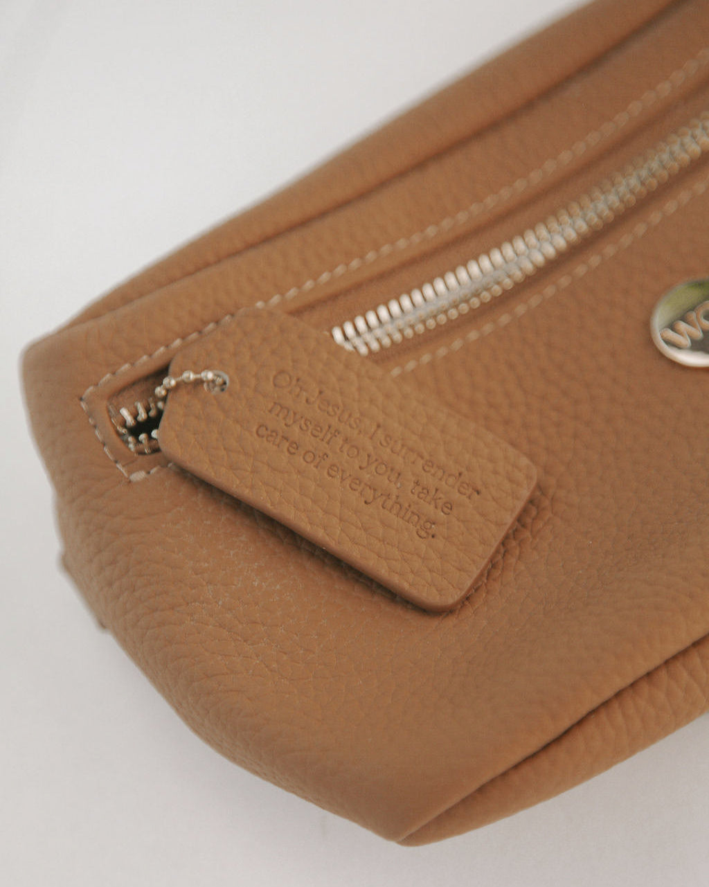 Close-up of a brown leather pouch with a zipper on a white background