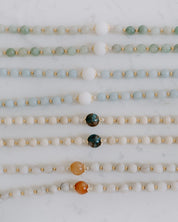 Set of beadedrosaries with various colored beads on a marble surface