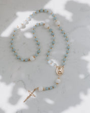 Blue gemstone rosary on a marble background