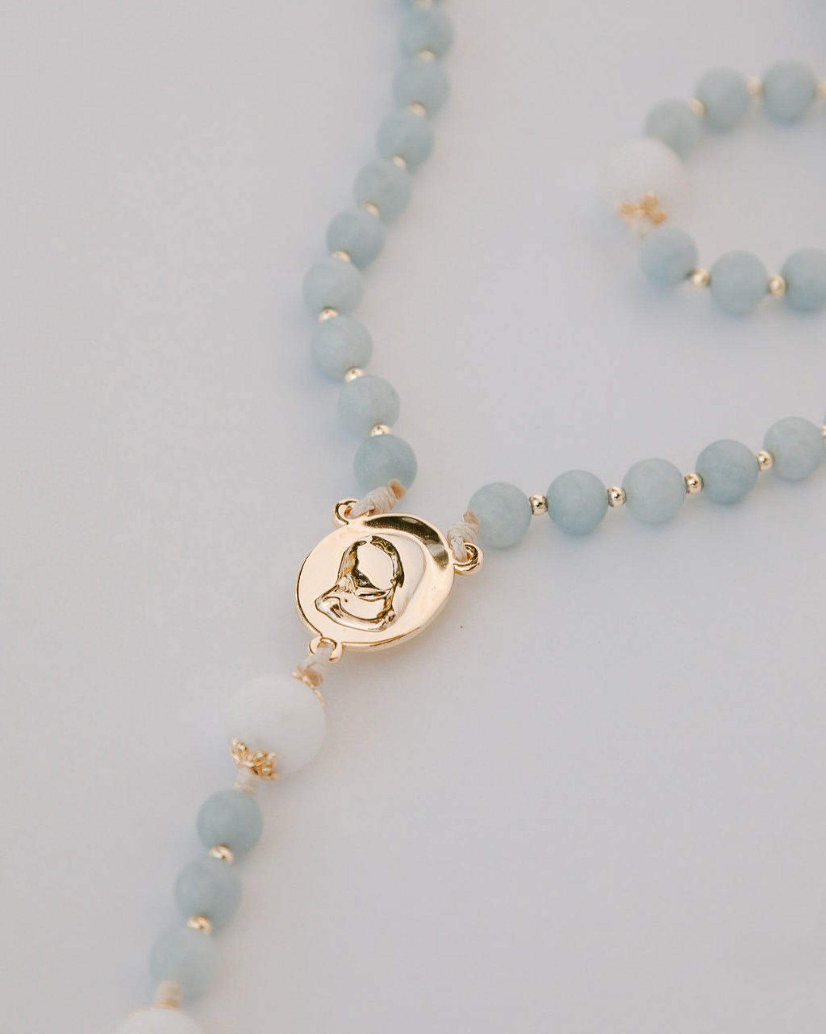 medjugorje rosary gold medal detail on white background