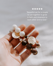 Hand holding two beaded rosaries with a 5 star review