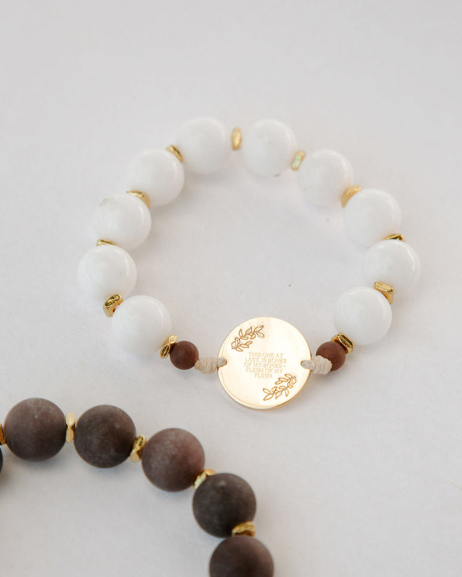 Two beaded rosaries with gold accents on a light gray background