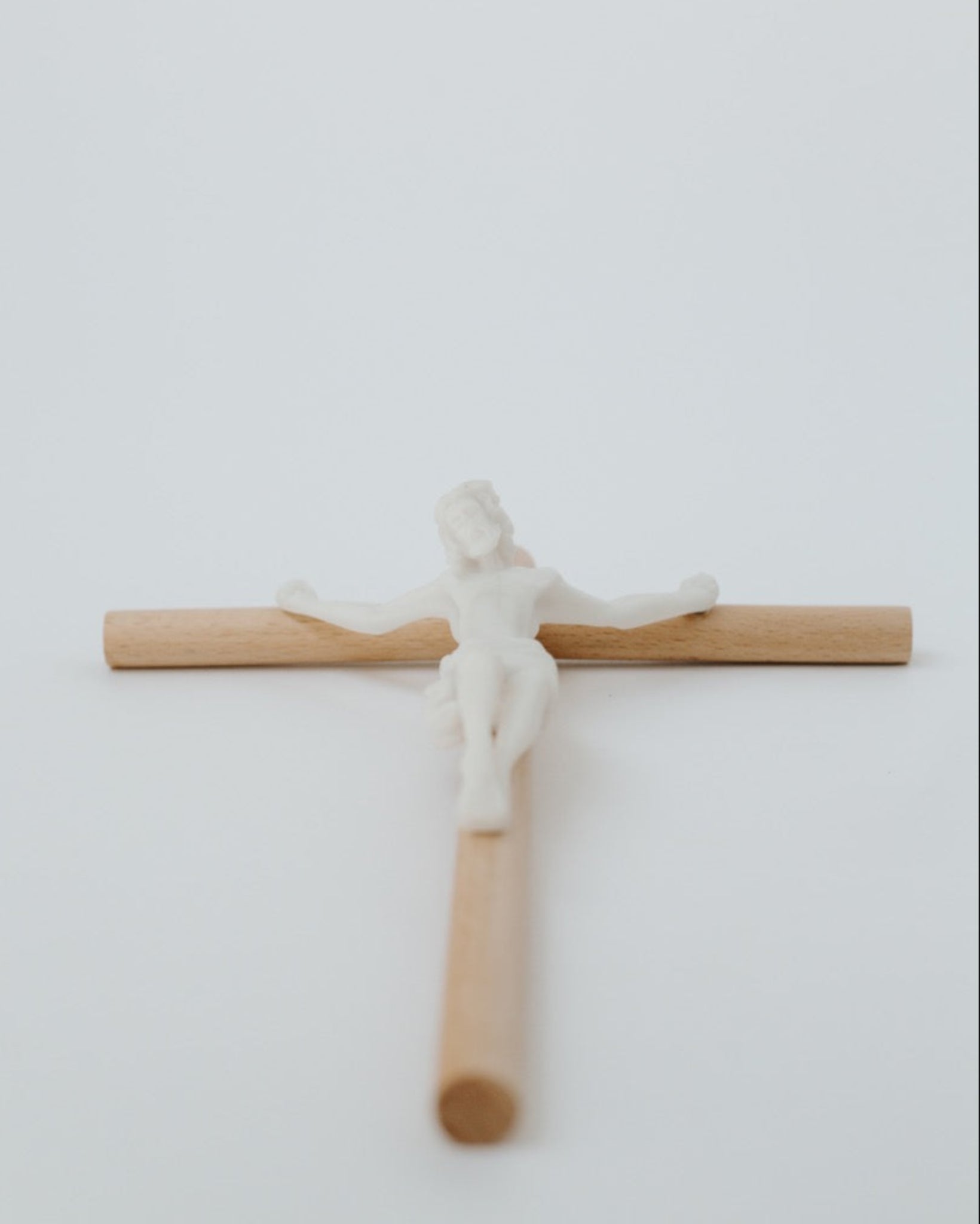 Modern wall crucifix lying on white background