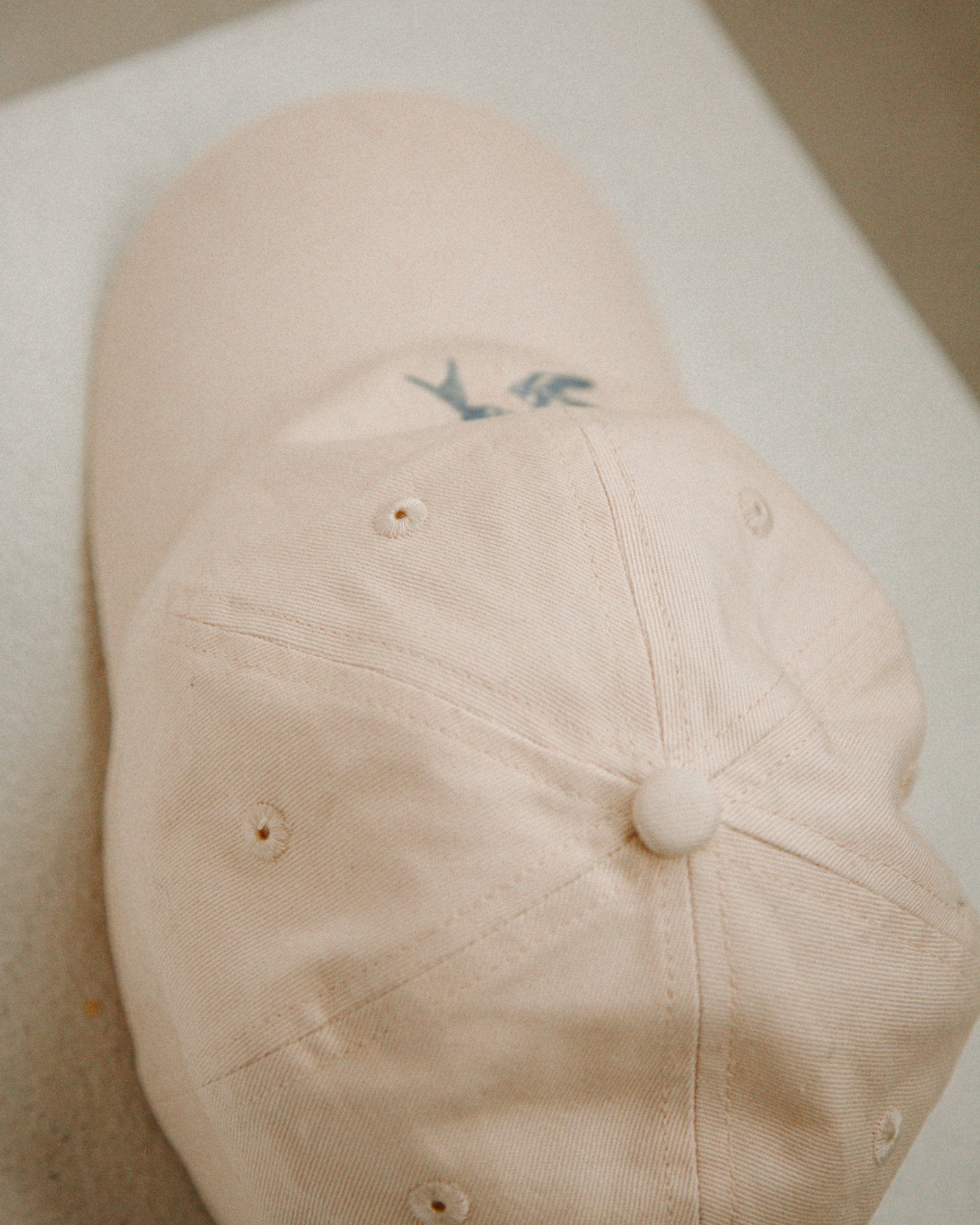 Beige cap with a logo on a white surface