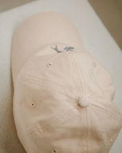 Beige cap with a logo on a white surface