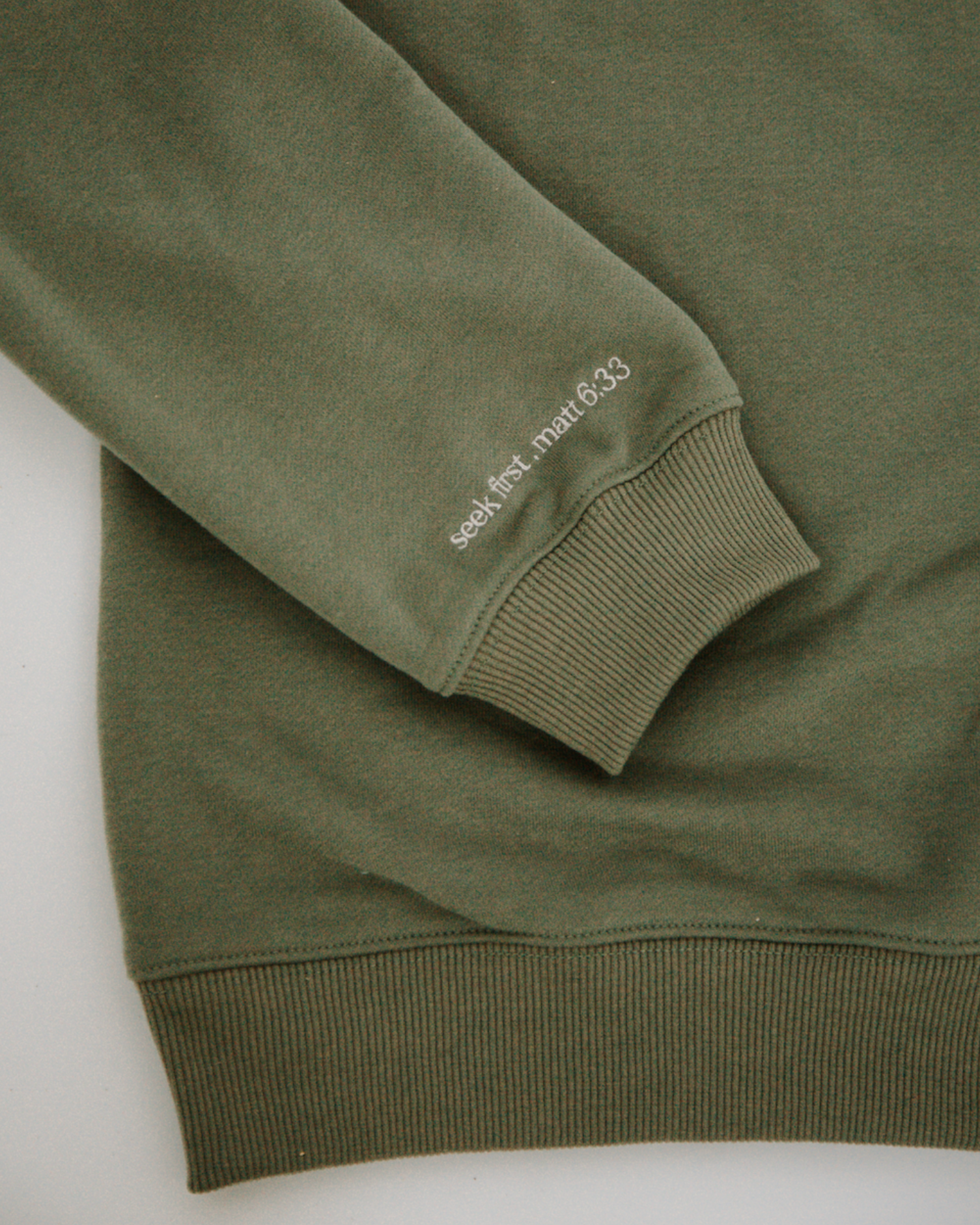 Green crewneck with bible verse embroidered on sleeve