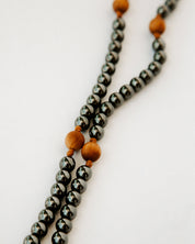 Rosary with gunmetal and wood beads on a white background