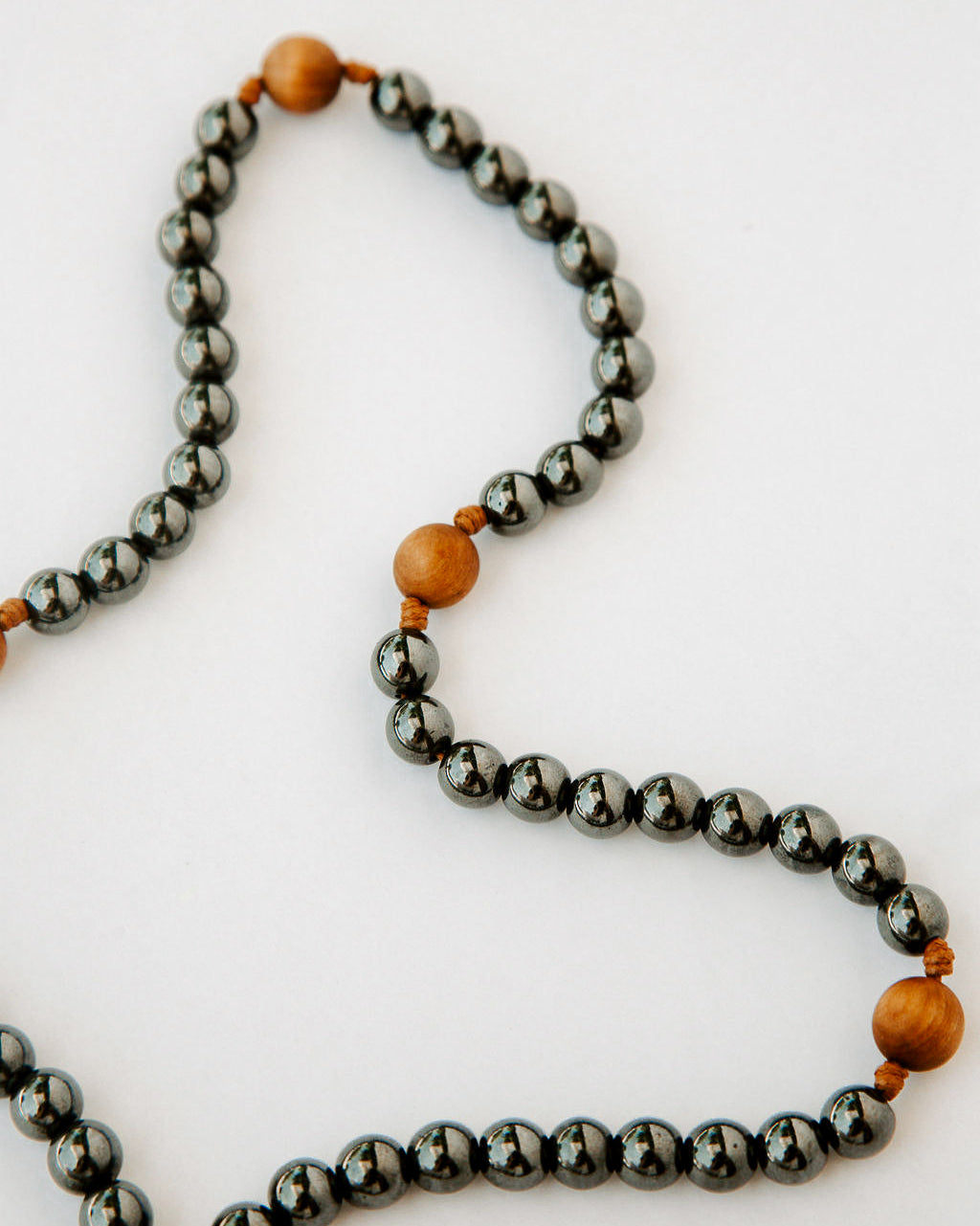 Rosary with black metal and wood beads on a white background
