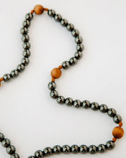 Rosary with black metal and wood beads on a white background