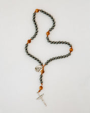 Rosary with metal and wood beads on white background