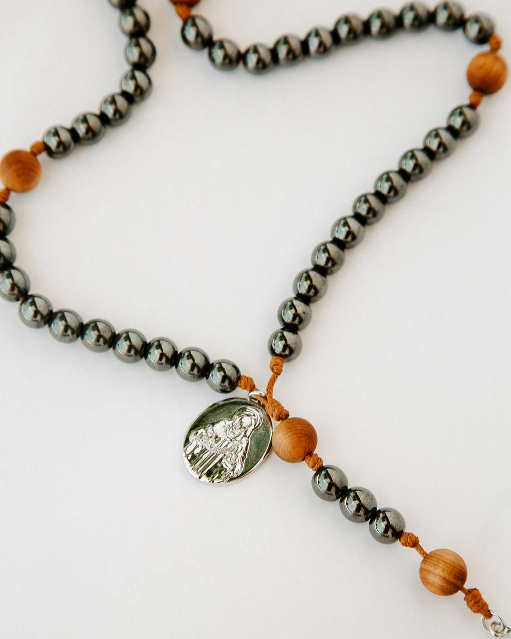 Rosary with gunmetal and wood beads on a white background