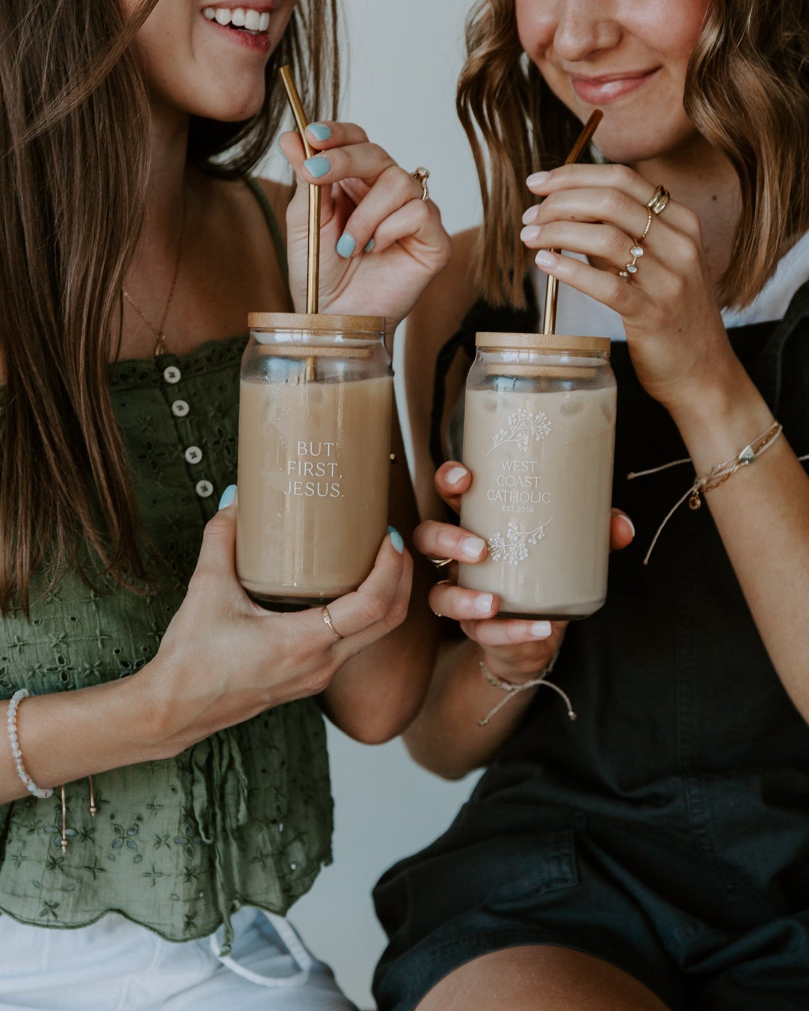 woman holding jesus first glass tumbler with gold straw and bamboo lid