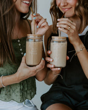 woman holding jesus first glass tumbler with gold straw and bamboo lid