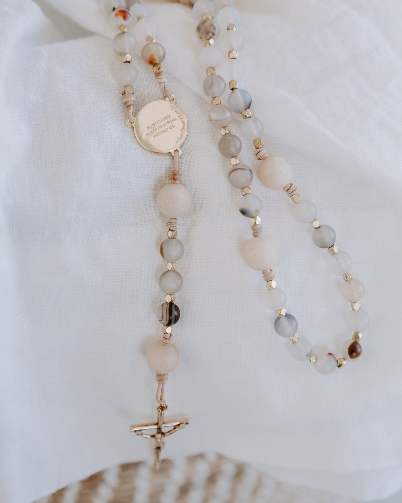 Rosary with multicolored beads on a white blanket