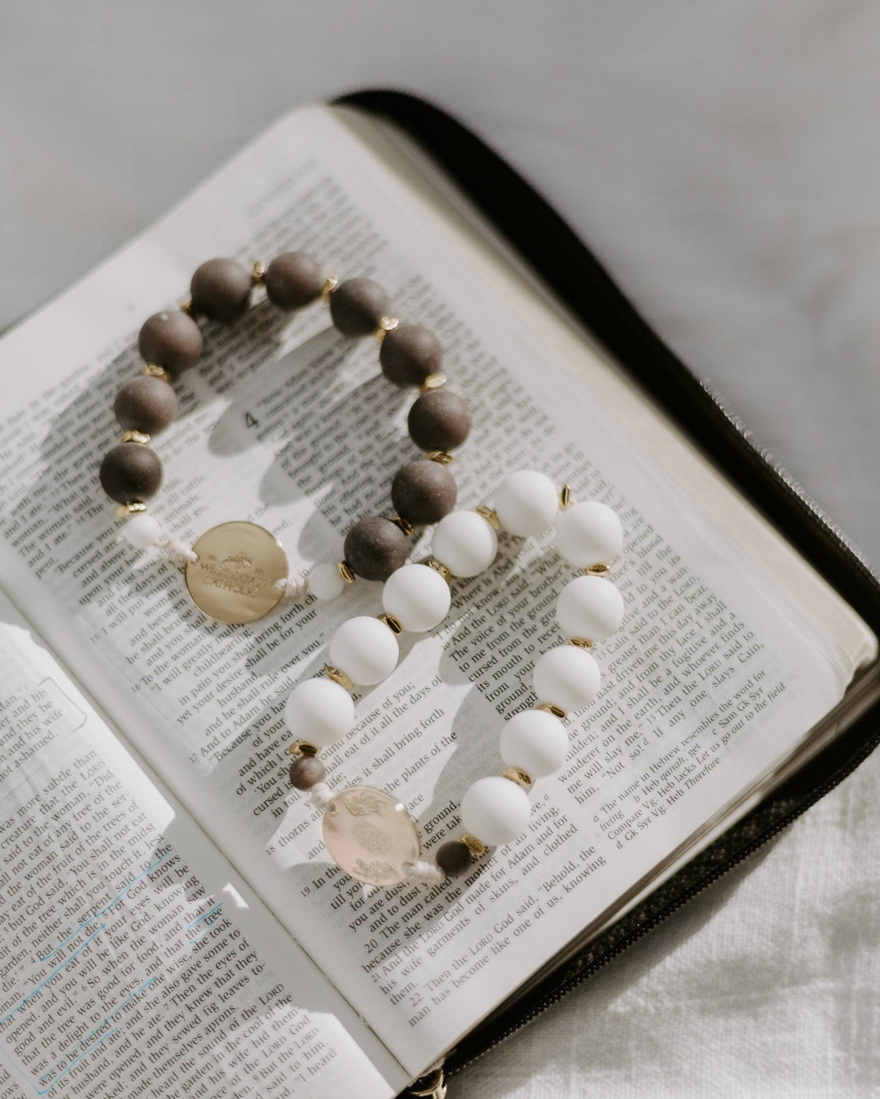 Rosary with wooden and white beads on an open book