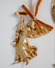 Gold angel ornament with a ribbon on a white background