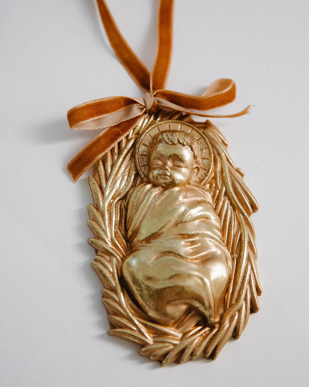 Gold ornament with a figure and leaves on a white background
