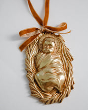 Gold ornament with a figure and leaves on a white background