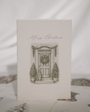 Christmas card with a door and wreath illustration on a white background