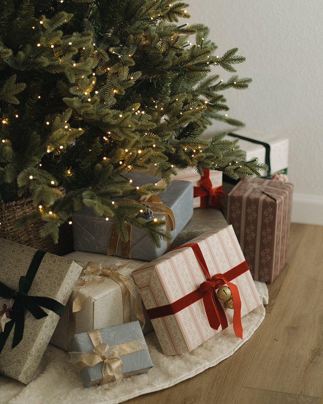 Decorated Christmas tree with wrapped gifts on a wooden floor