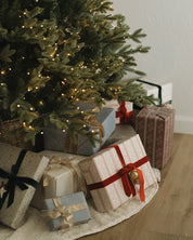 Decorated Christmas tree with wrapped gifts on a wooden floor