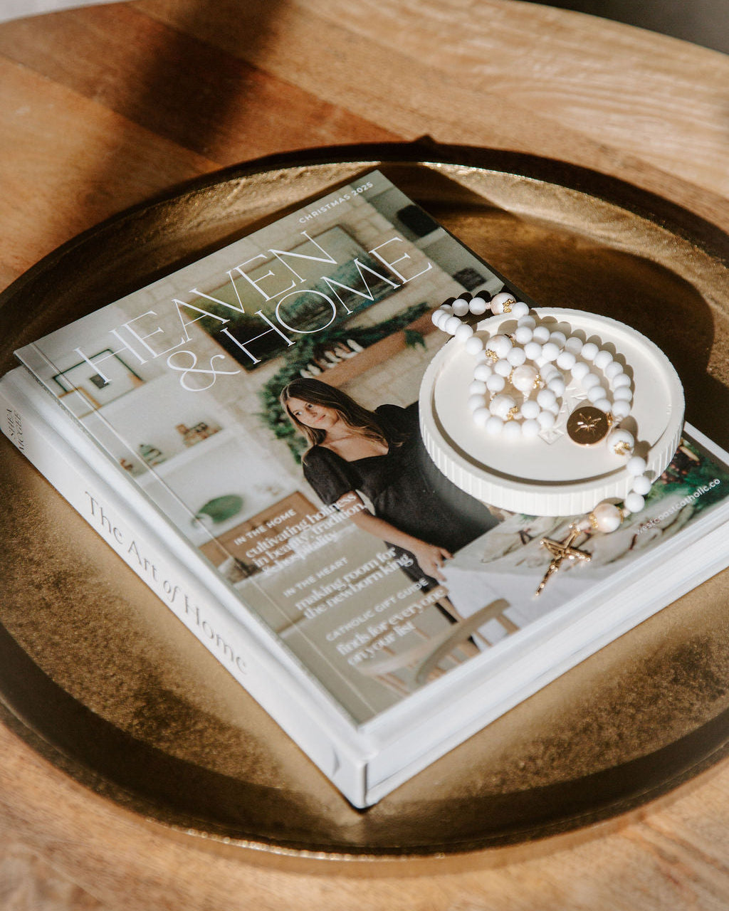 Magazine titled Heaven & Home' with rosary on a wooden surface