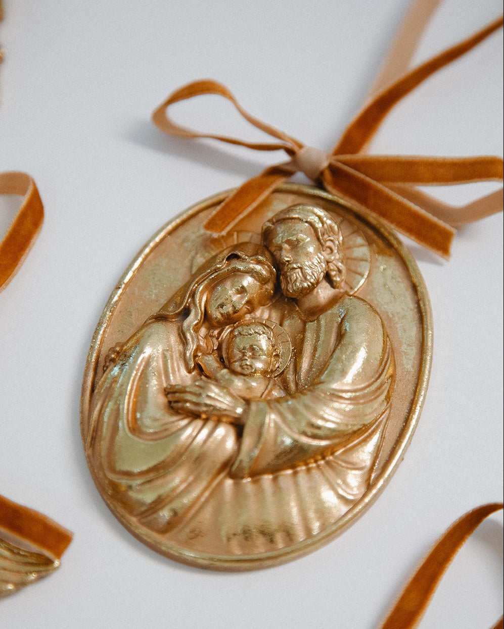 Gold religious medallion with a ribbon on a white background