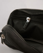 Close-up of a black bag with zippers on a light gray background