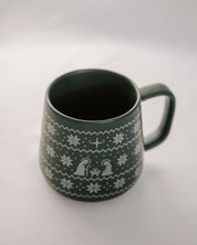 Green mug with white pattern on a light gray background