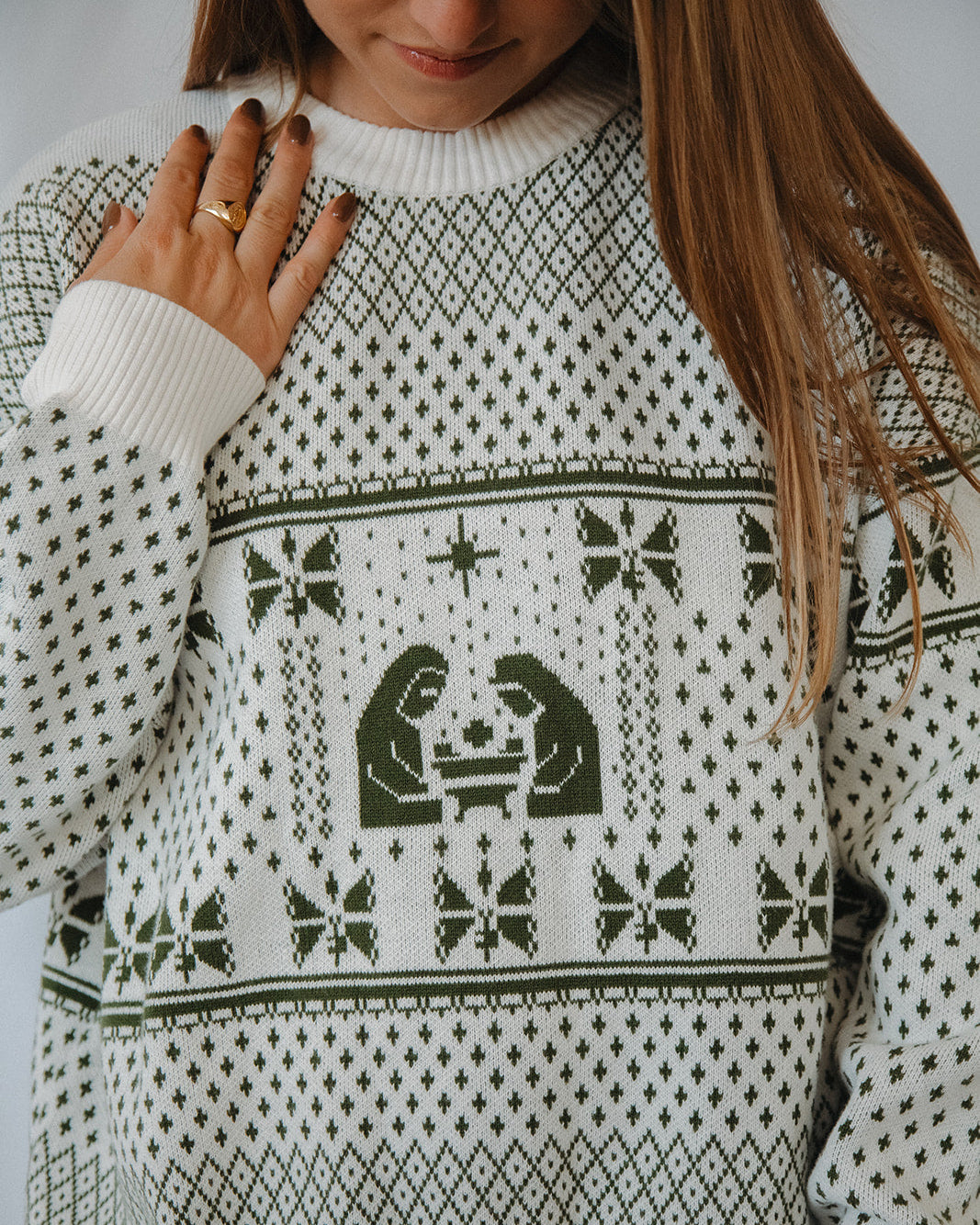 Person wearing a white and green christmas sweater with green pattern