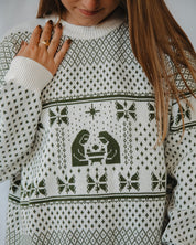Person wearing a white and green christmas sweater with green pattern