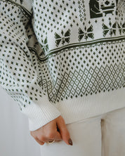 Close-up of a person wearing a white sweater with black pattern