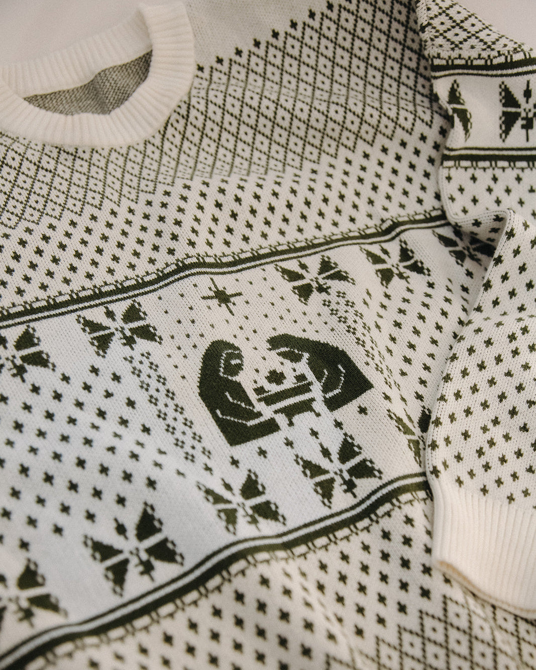 Close-up of a sweater with black geometric patterns on a white background