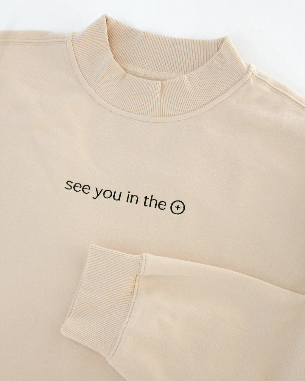 Beige sweatshirt with text 'see you in the eucharist' on a white background