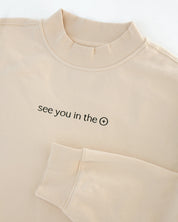 Beige sweatshirt with text 'see you in the eucharist' on a white background