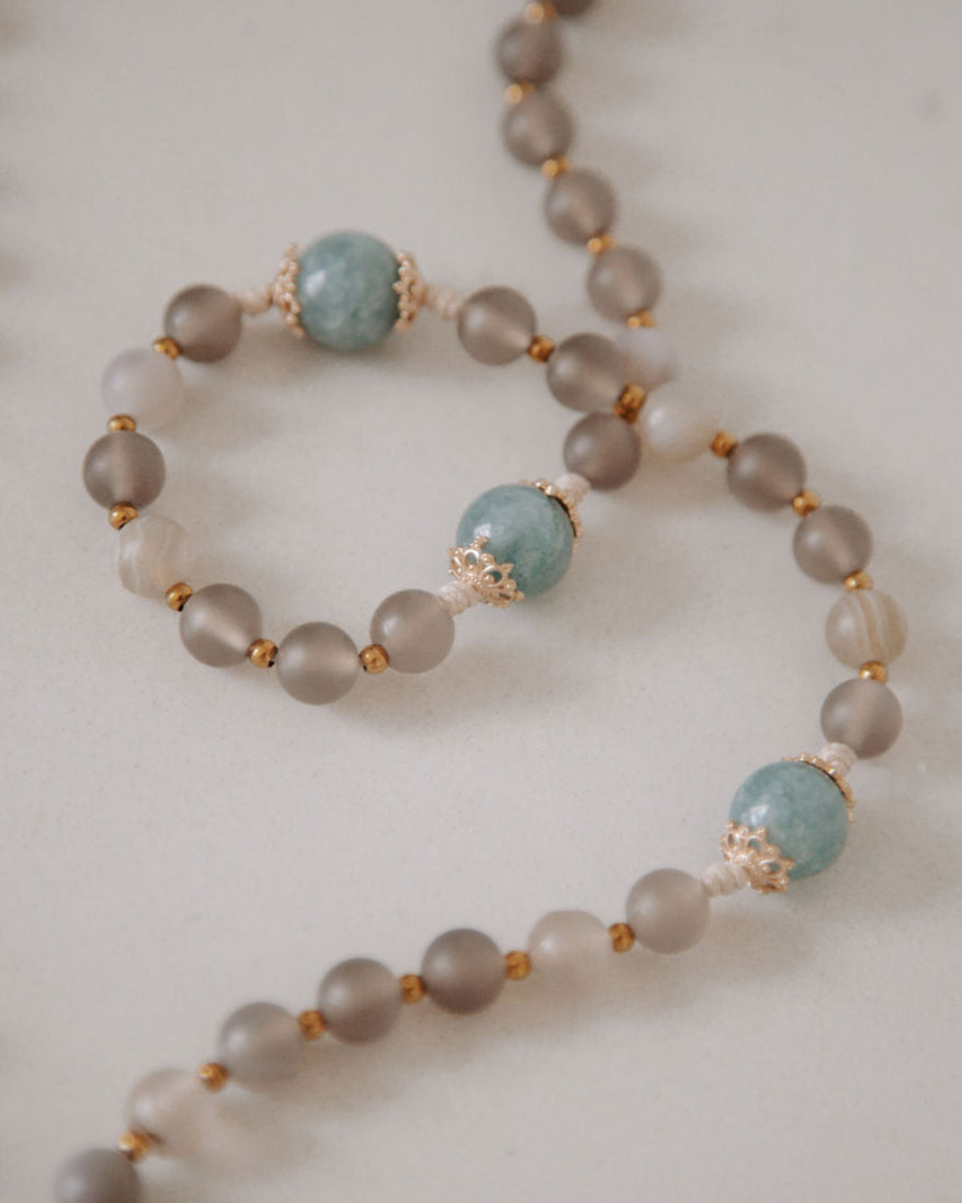 Brown and blue beads with gold accents on a white background