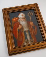 Framed painting of a robed figure with a staff on a white wall