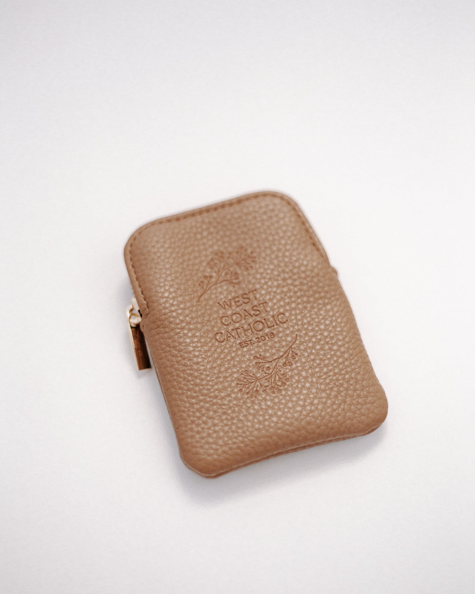 Brown leather rosary pouch with embossed logo on a white background