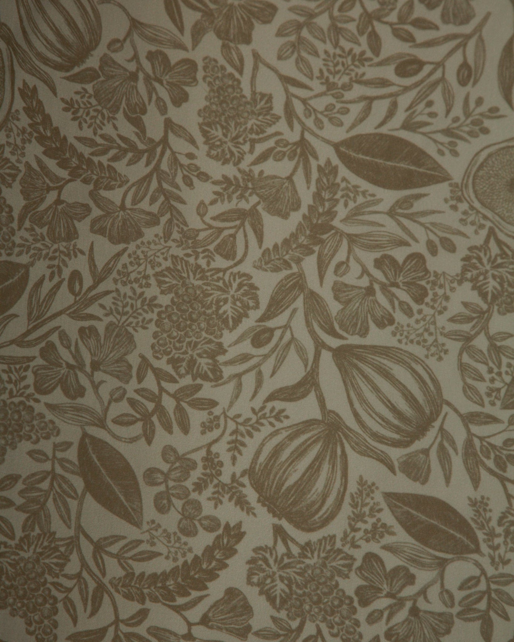 A close-up of a botanical patterned wallpaper or fabric featuring brown floral and leaf motifs on a warm beige background.