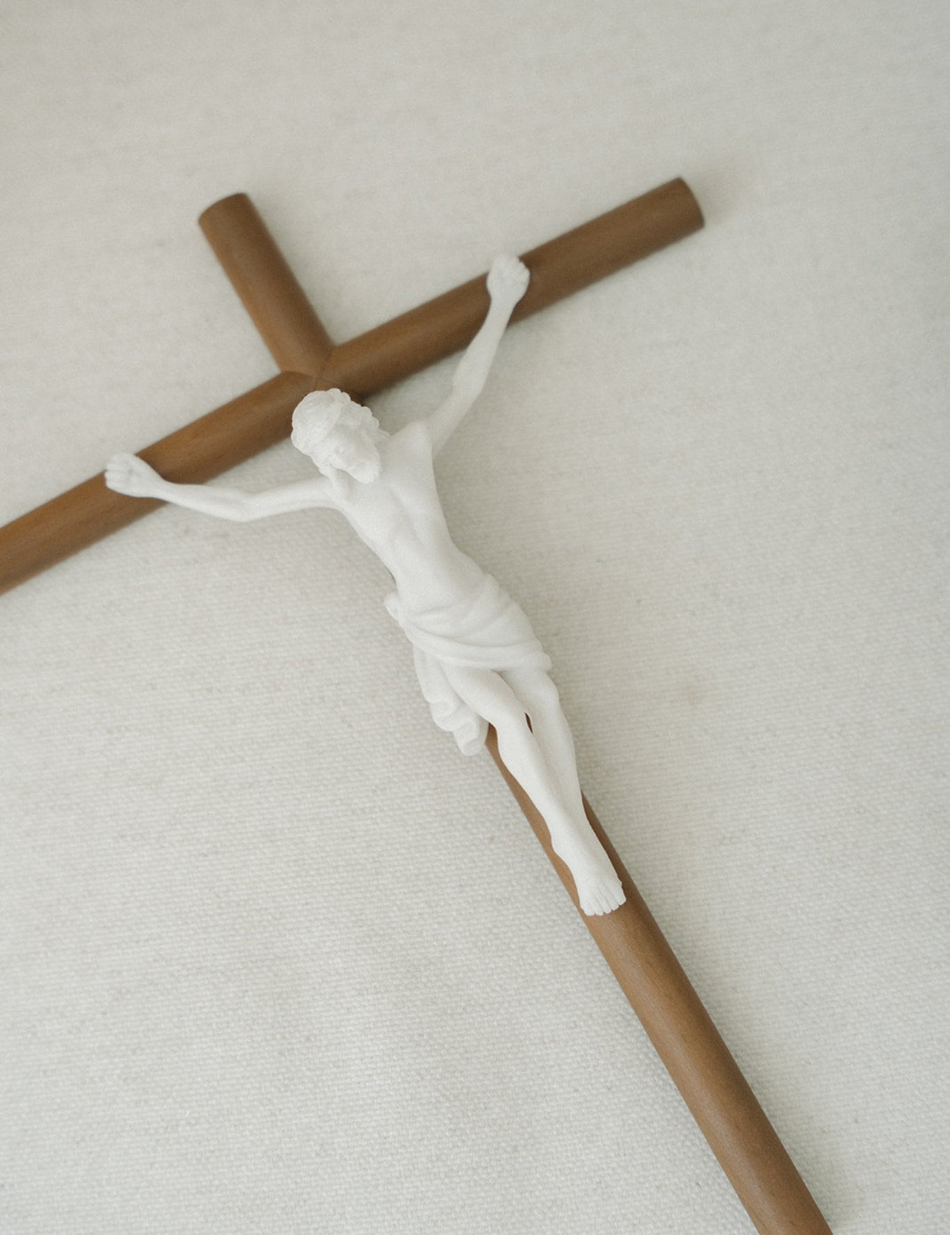 Model of a crucifix with a white jesus figure on a light gray background