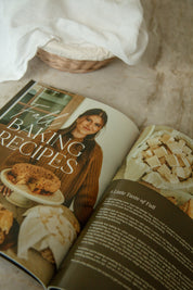 Heaven & Home Catholic magazine open to the Fall Baking Recipes feature, styled with fresh-baked fall treats and a linen-lined basket on a marble counter.